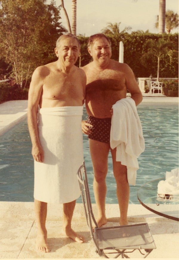 Max Fisher standing with friend beside pool.