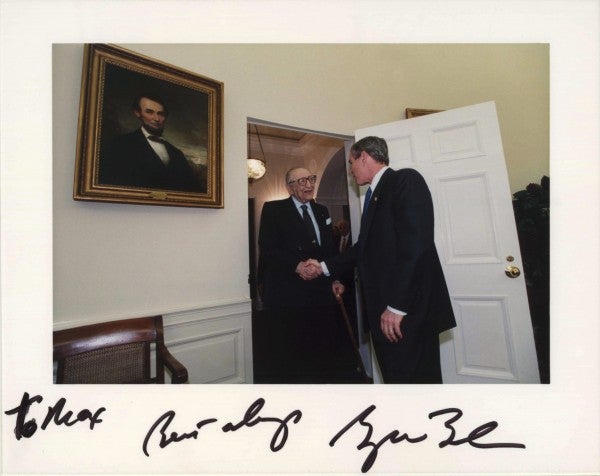Max Fisher and George W. Bush shaking hands in the Oval Office.