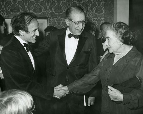 Elie Weisel, Max Fisher and Golda Meir shaking hands.